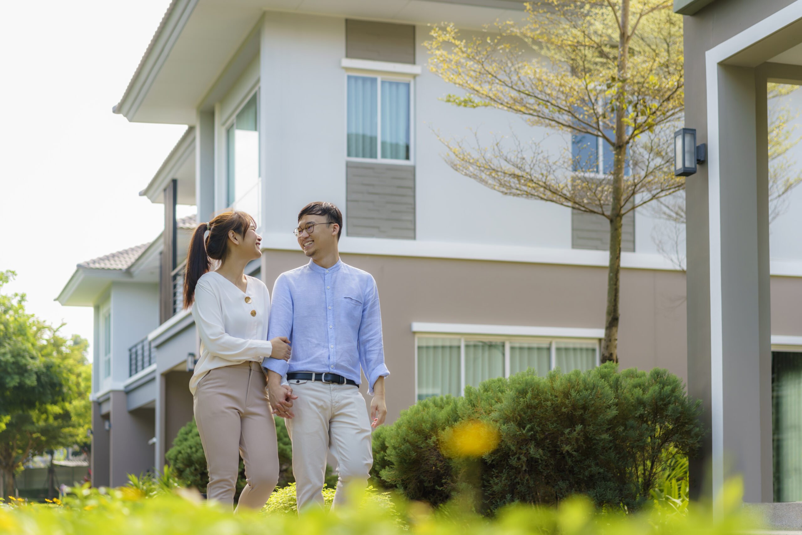 portrait asian couple walking hugging together looking happy front their new house start new life scaled